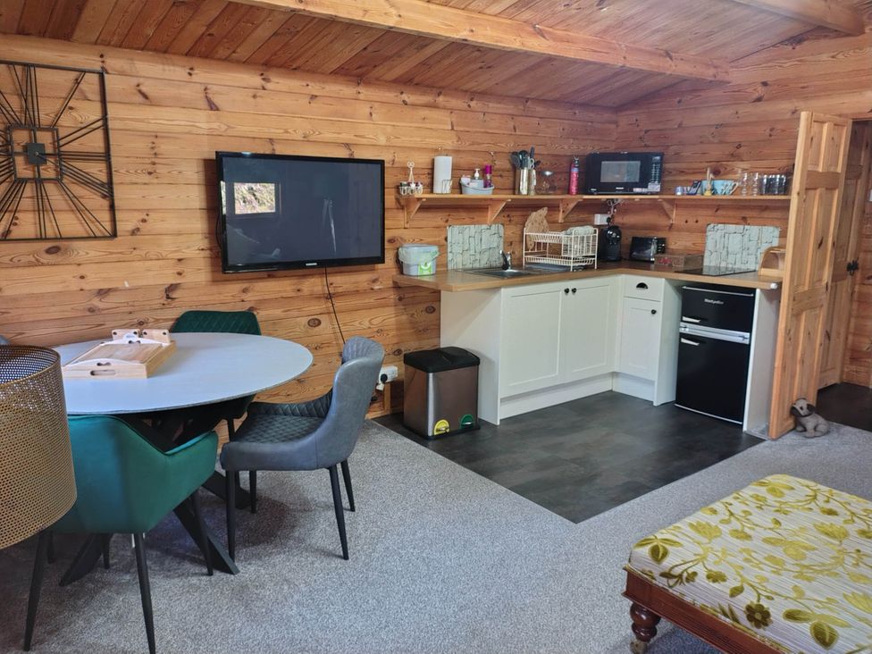 A kitchen with appliances and dining area at Forest Cabin Retreat-Sleeps 2-Garden, Wifi, Trails in Alderholt