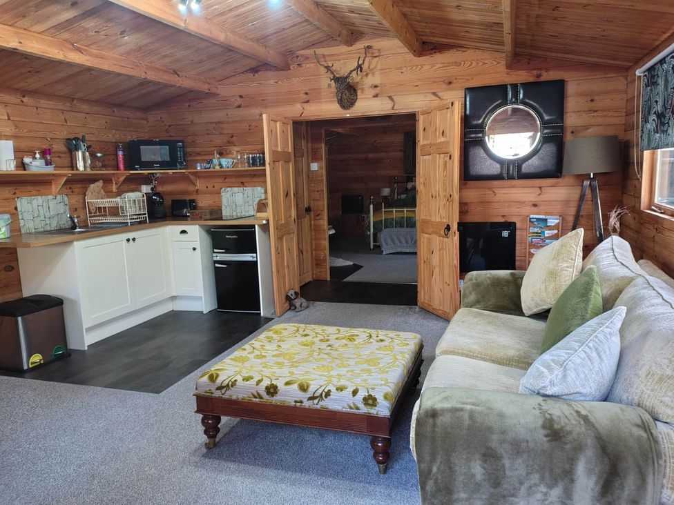 A living room with a sofa and coffee table at Forest Cabin Retreat-Sleeps 2-Garden, Wifi, Trails, Alderholt