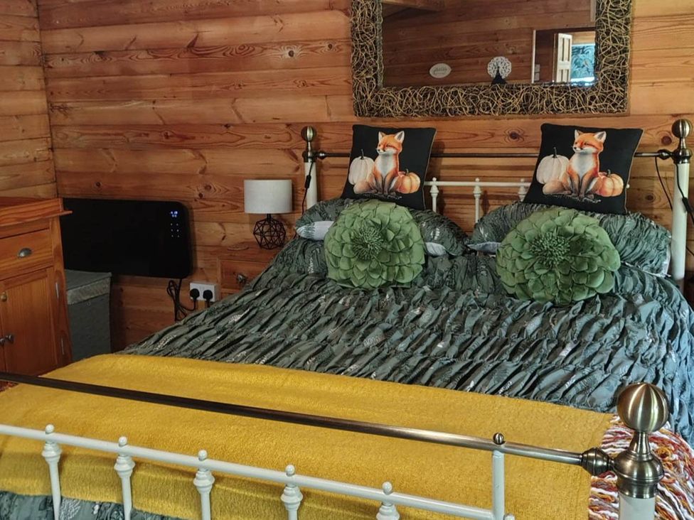 A bedroom with a bed and decorative pillows at Forest Cabin Retreat-Sleeps 2-Garden, Wifi, Trails in Alderholt