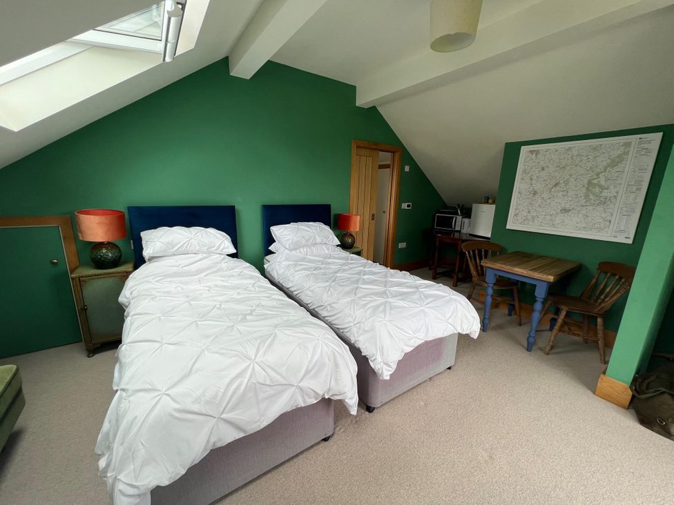 A bedroom with two beds and a table at 2 Guests Studio - Free Parking - Stunning Views near Bruton