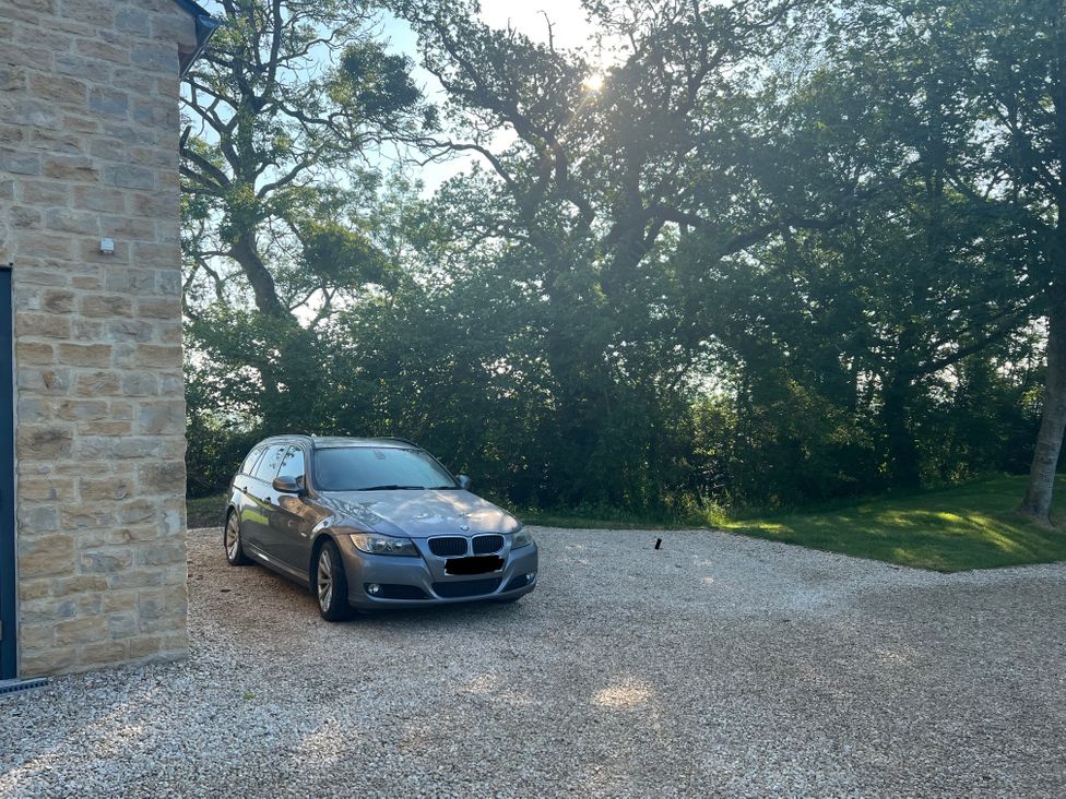 A car parked in a gravel driveway at 2 Guests Studio - Free Parking - Stunning Views near Bruton