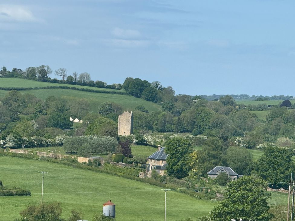 A landscape featuring a tower and houses in a rural area near Bruton