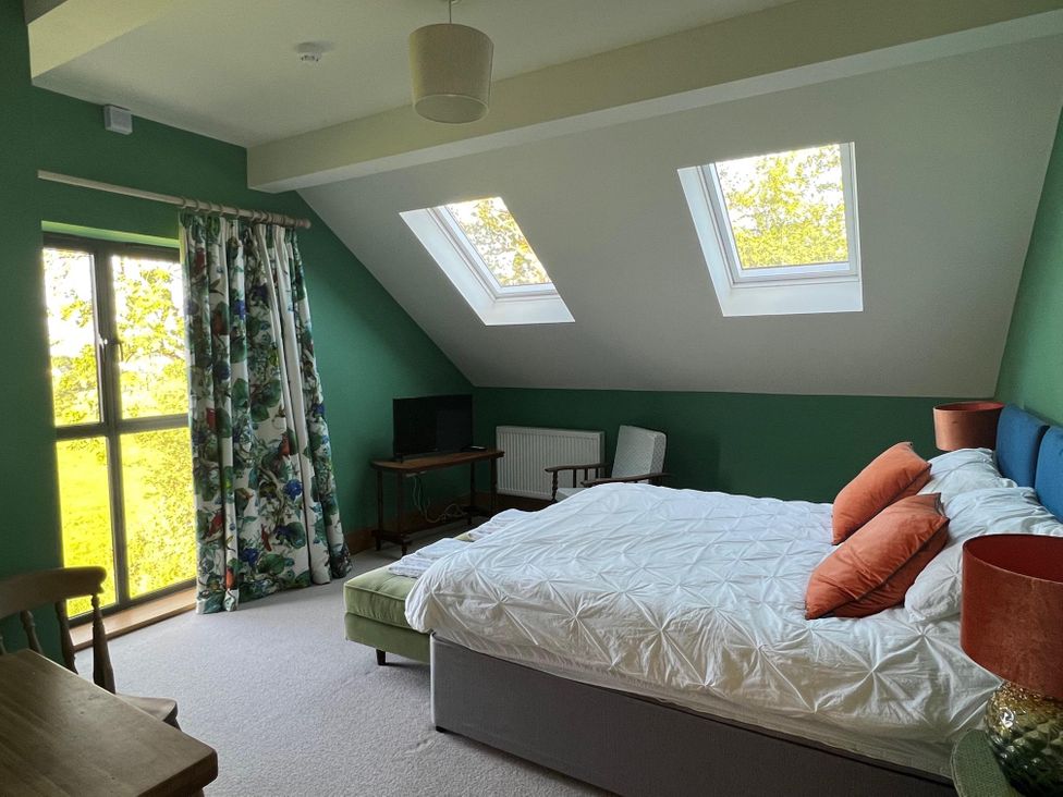 A bedroom with a bed and windows at 2 Guests Studio - Free Parking - Stunning Views near Bruton