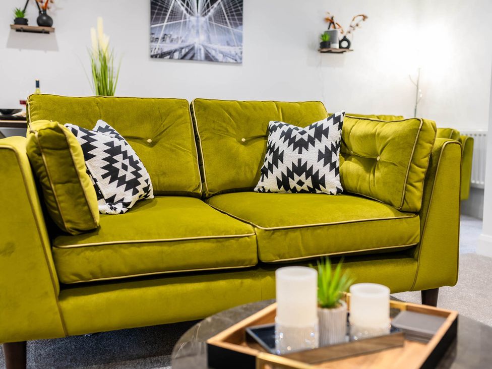 A sofa with cushions and a coffee table in a living room at Cosy 2-Bed Apartment in Nettleham