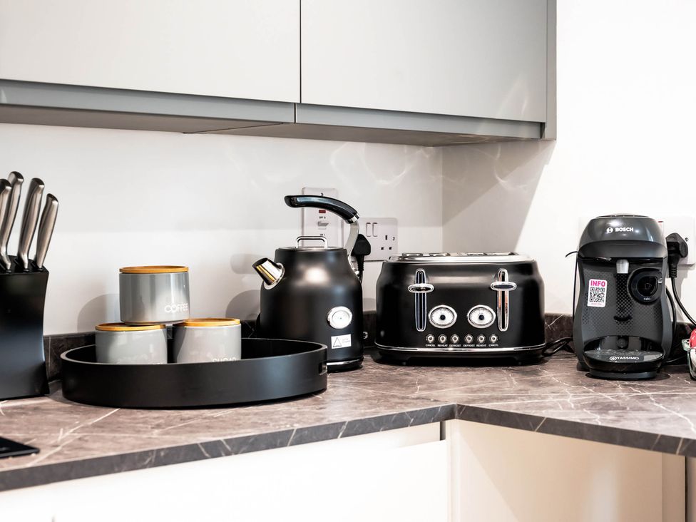 A kitchen with appliances including a kettle, toaster, and coffee machine at Cosy 2-Bed Apartment in Nettleham