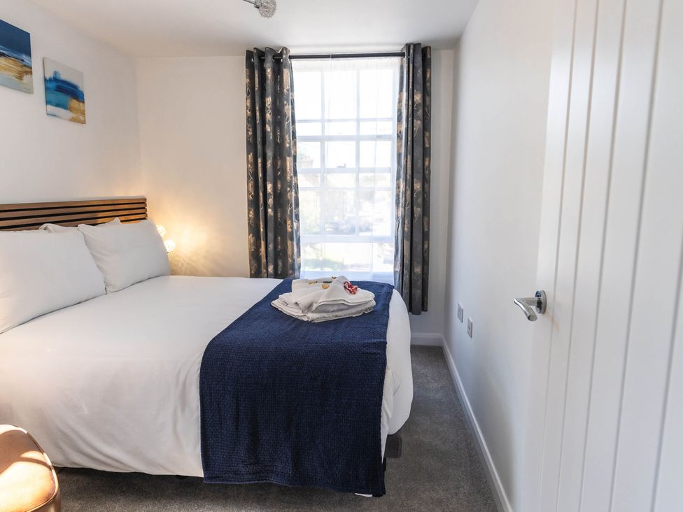 A bedroom with a bed and window at Cosy 2-Bed Apartment in Nettleham