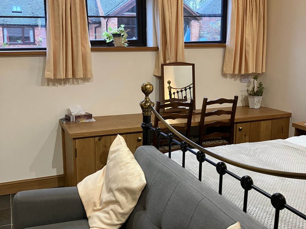 A bedroom with a bed and dressing table at Cottage in Nuneaton - Sleeps 2 - Parking - Garden Higham-on-the-Hill near Nuneaton