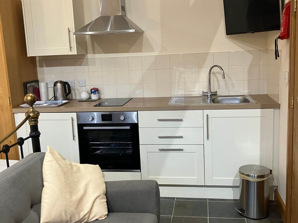 A kitchen with an oven, sink, and kettle at Cottage in Nuneaton - Sleeps 2 - Parking - Garden in Higham-on-the-Hill near Nuneaton