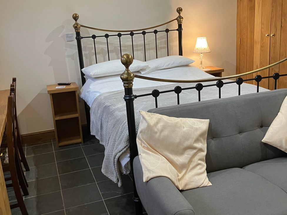 A bedroom with a bed and couch at Cottage in Nuneaton - Sleeps 2 - Parking - Garden Higham-on-the-Hill near Nuneaton