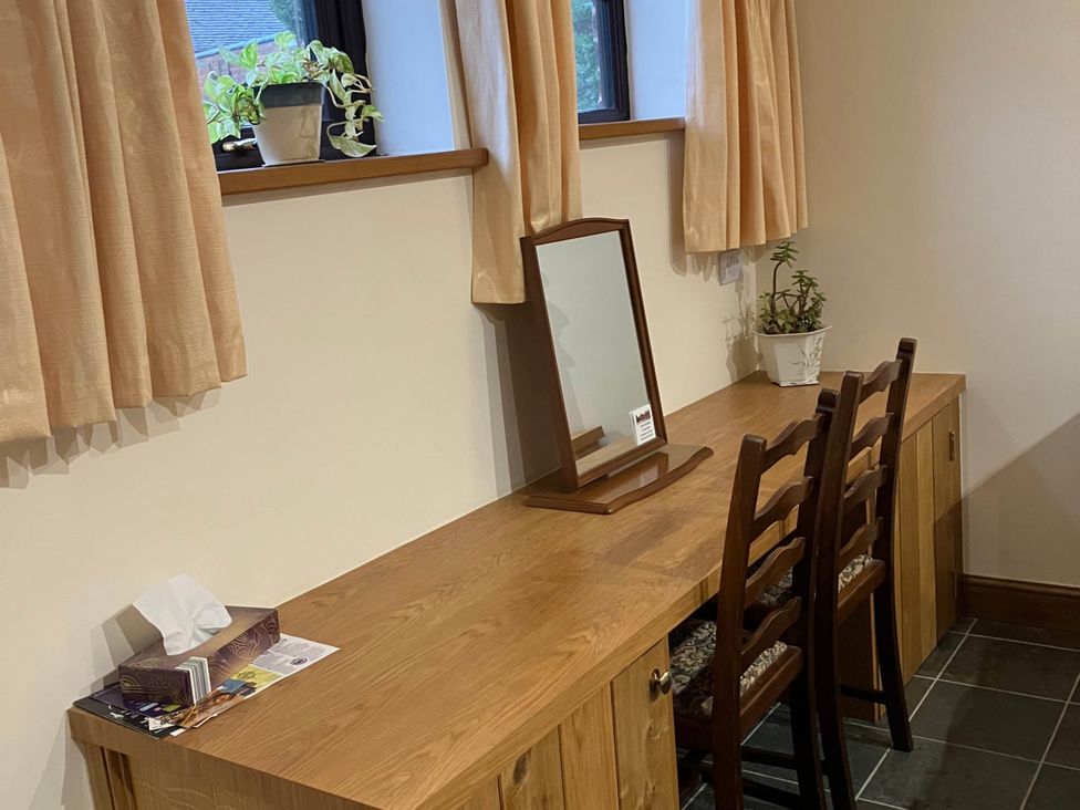 A dressing area with a table, mirror, and chairs at Cottage in Nuneaton - Sleeps 2 - Parking - Garden in Higham-on-the-Hill near Nuneaton