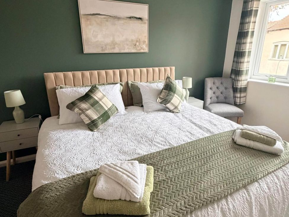 A bedroom with a bed, nightstand, and chair at Meriden Apartment - Sleeps 7 - Near Nec, Parking, Meriden