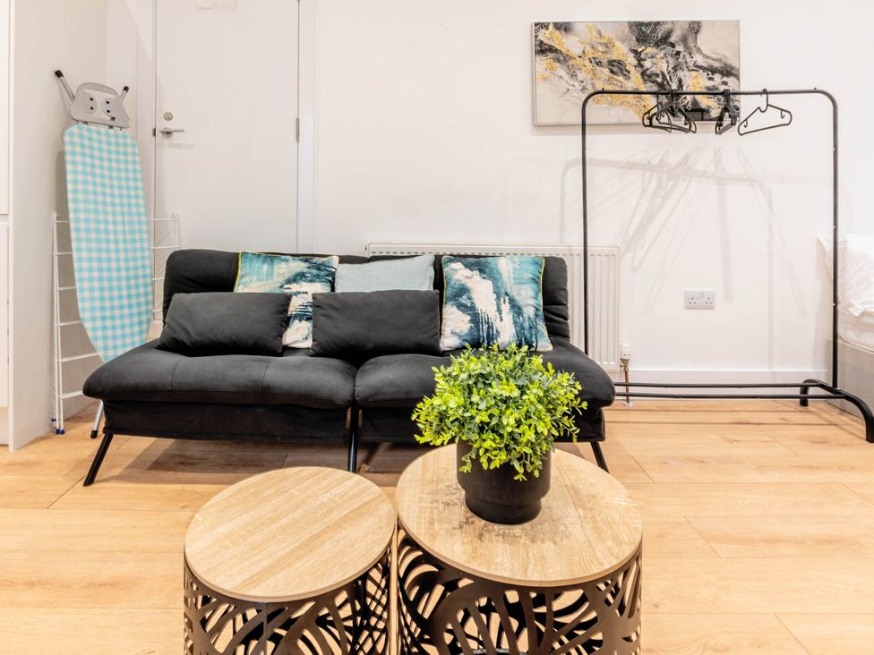 A living room with a sofa and plant at Central - Sleeps 2 - Near Transport - Parking in Maidenhead