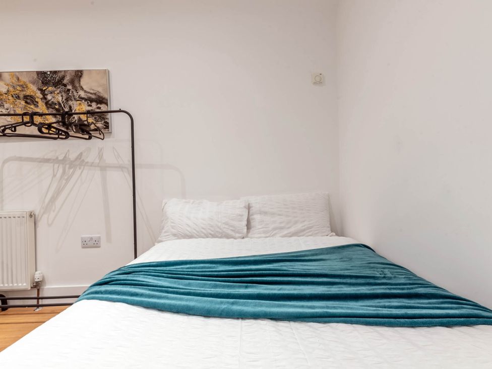 A bedroom with a bed and hangers on a wall at Central - Sleeps 2 - Near Transport - Parking in Maidenhead