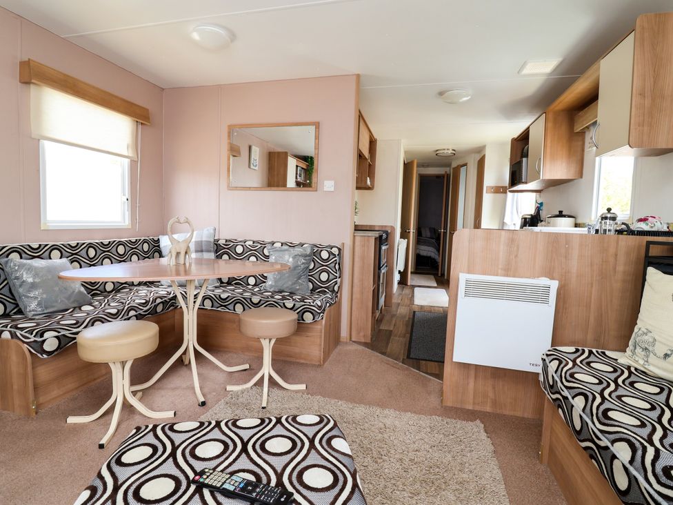 A living room with bench seating and a table at Plot 594 in Prestatyn