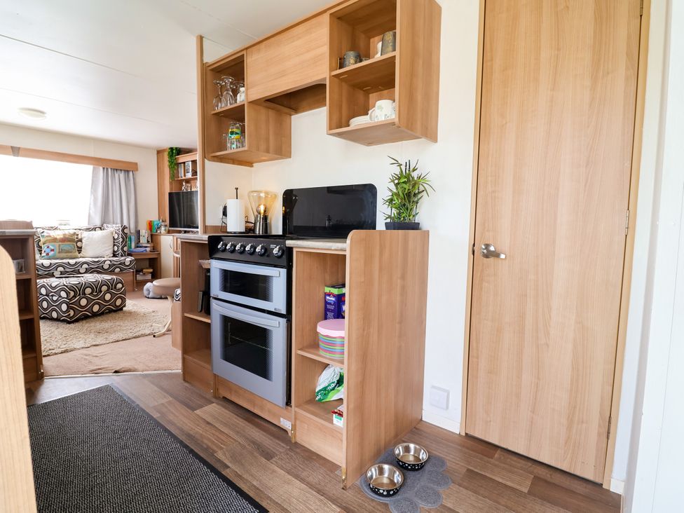 A kitchen with appliances and seating area at Plot 594 in Prestatyn