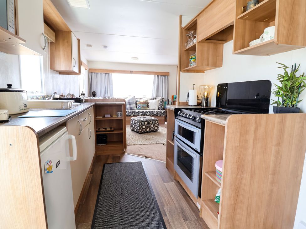 A kitchen with stove and refrigerator at Plot 594 in Prestatyn