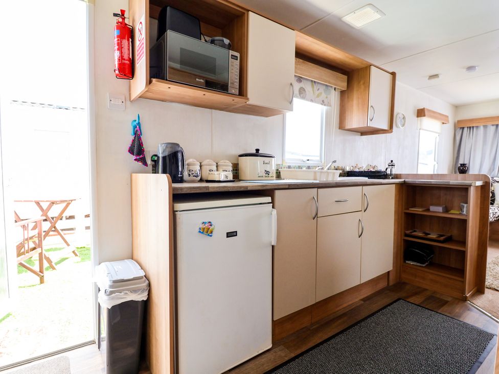 A kitchen with a microwave, sink, and refrigerator at Plot 594, Prestatyn