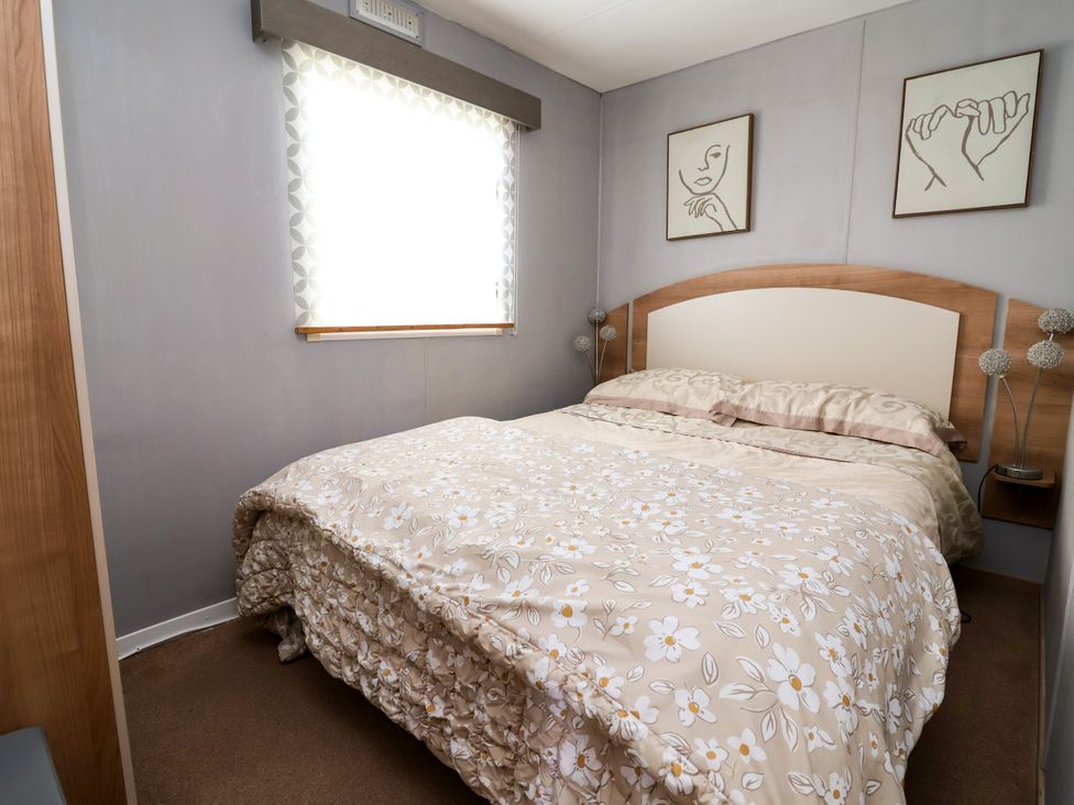 A bedroom with a bed and window at Plot 594 in Prestatyn