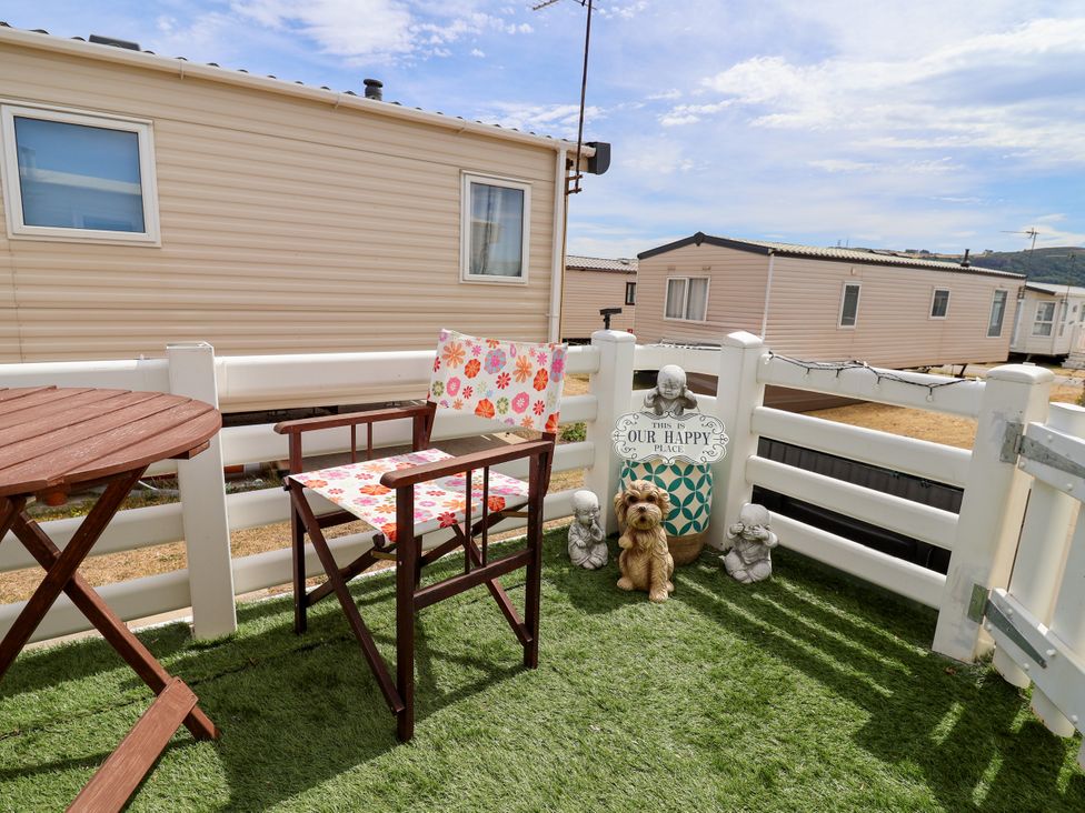 An outdoor seating area with a table and chair at Plot 594 in Prestatyn