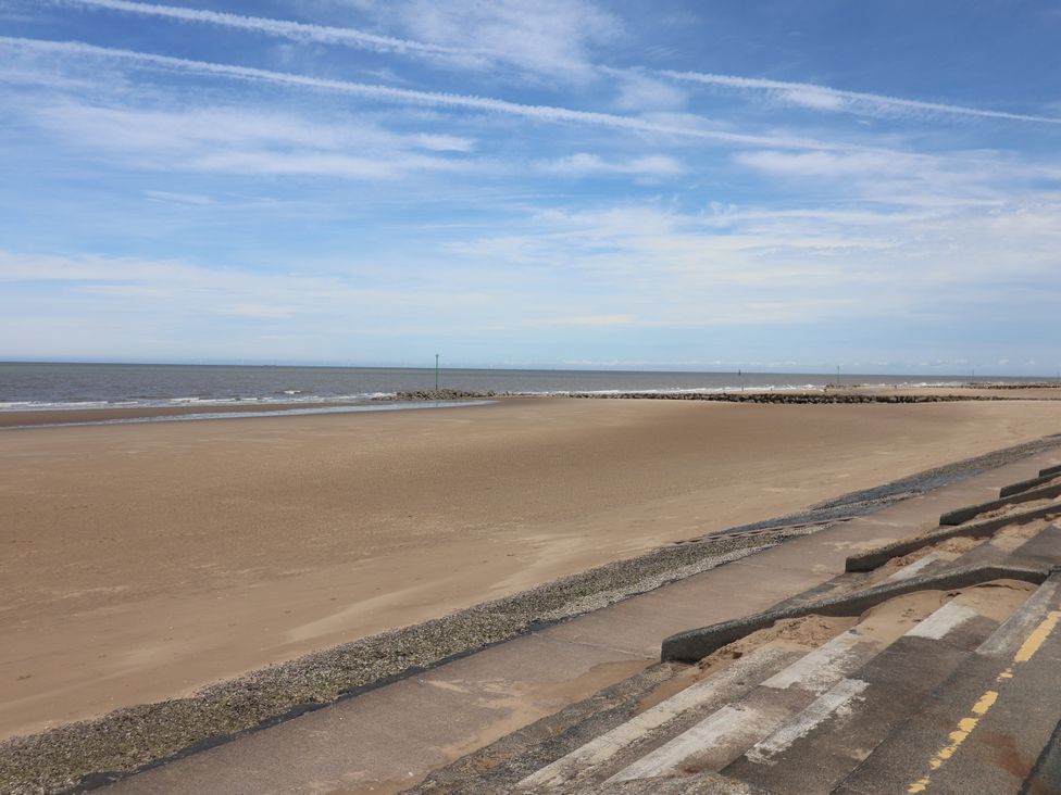 A beach with sand and ocean under a blue sky at Plot 594 in Prestatyn