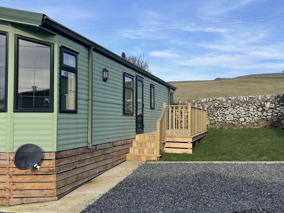An exterior view of a static caravan with steps and grass at Immaculate 2-Bed Static Caravan at Monreith near Whithorn