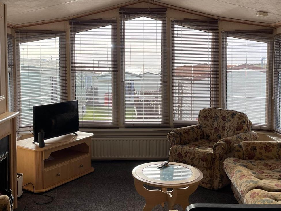 A living room with a television and sofas at Immaculate 2-Bed Static Caravan at Monreith