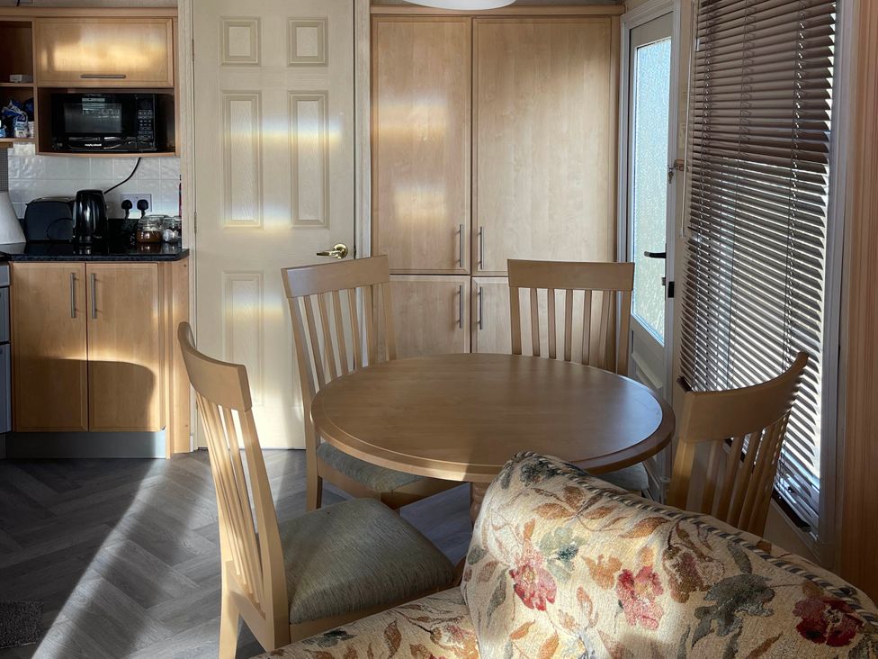 A dining area with a table and chairs at Immaculate 2-Bed Static Caravan at Monreith