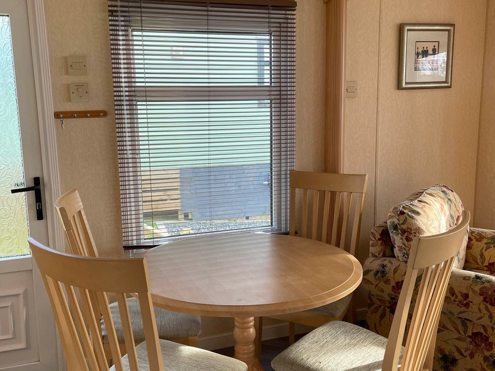 A dining area with a table and chairs at Immaculate 2-Bed Static Caravan at Monreith near Whithorn