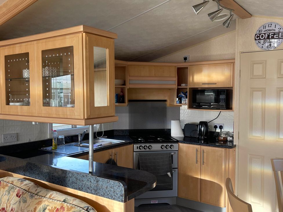 A kitchen with cabinets and appliances at Immaculate 2-Bed Static Caravan at Monreith