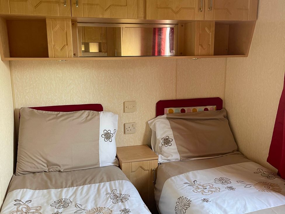 A bedroom with two single beds and a bedside table at Immaculate 2-Bed Static Caravan at Monreith