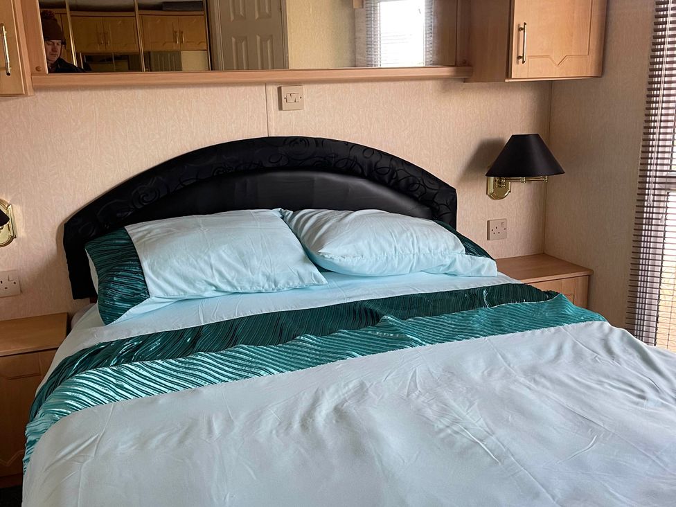 A bedroom with a bed and lamp at Immaculate 2-Bed Static Caravan at Monreith near Whithorn