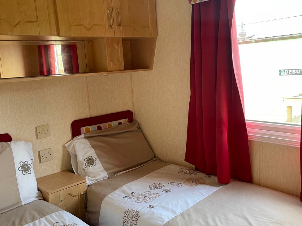 A bedroom with twin beds and shelving at Immaculate 2-Bed Static Caravan at Monreith near Whithorn