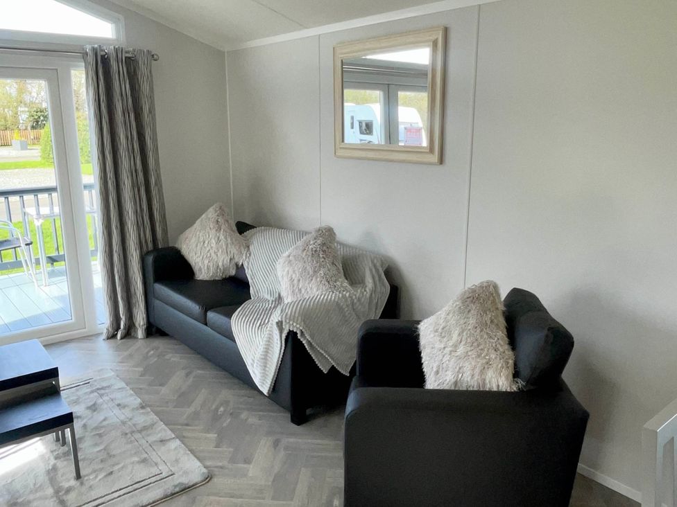 A living room with two sofas and a mirror at Chalet 4 guests Parking Available near Tuxford