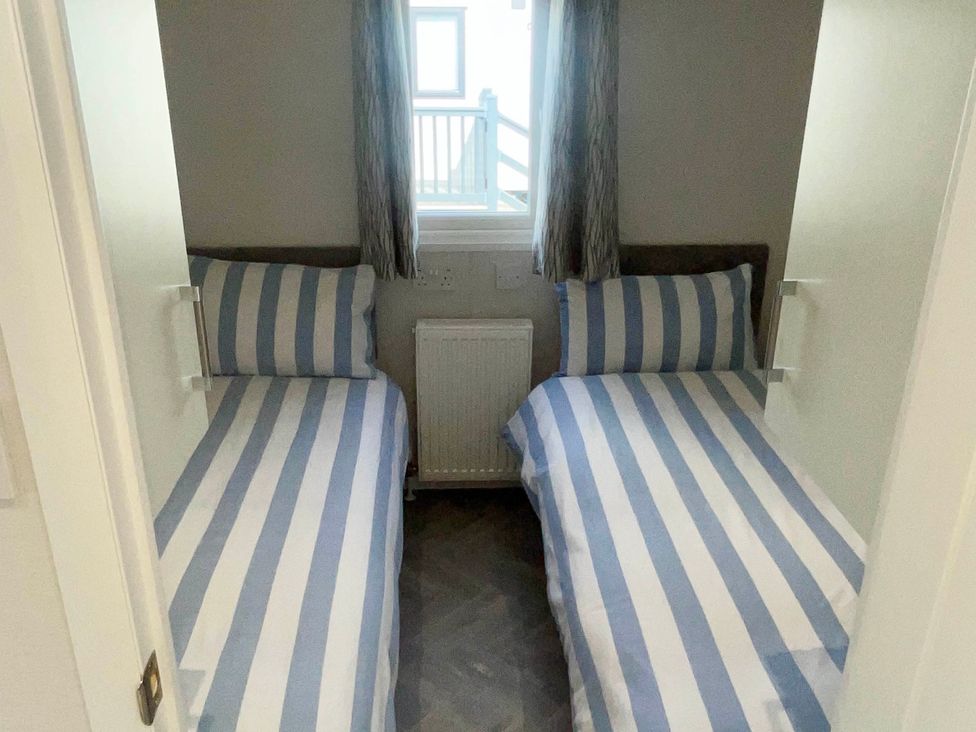 A bedroom with two single beds and a window at Chalet 4 guests Parking Available near Tuxford