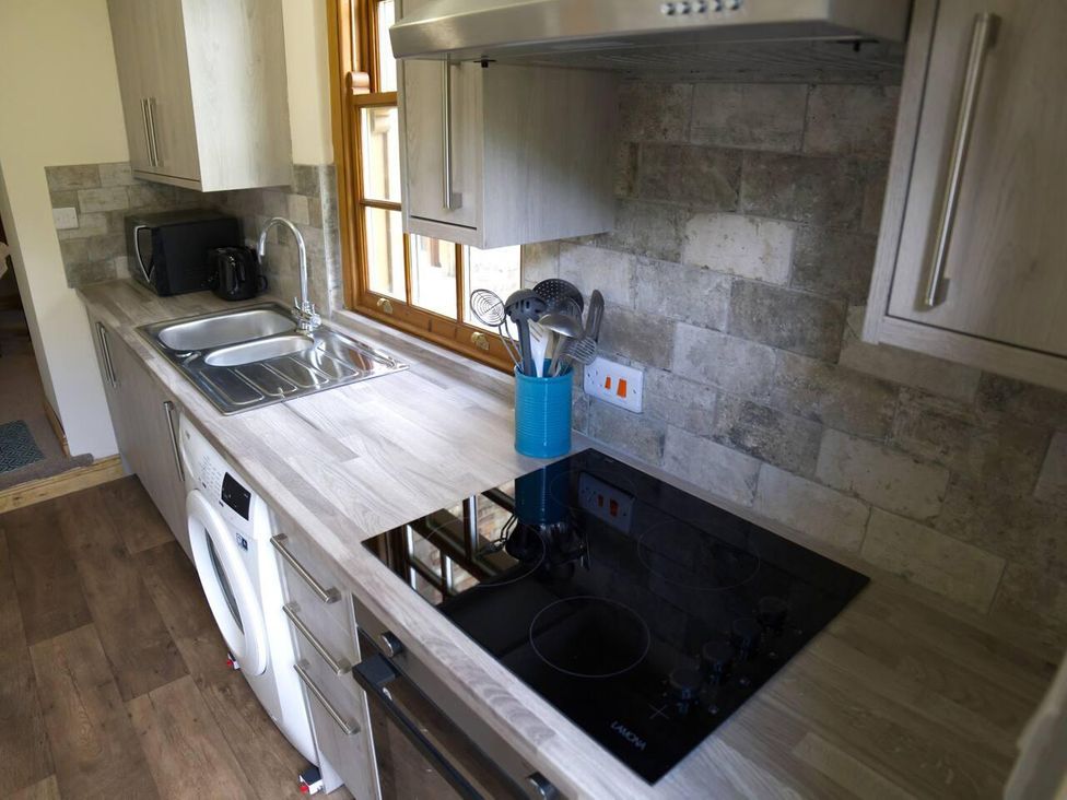 A kitchen with a sink, oven, and washing machine at Cottage Sleeps 2 Garden Parking Ryton