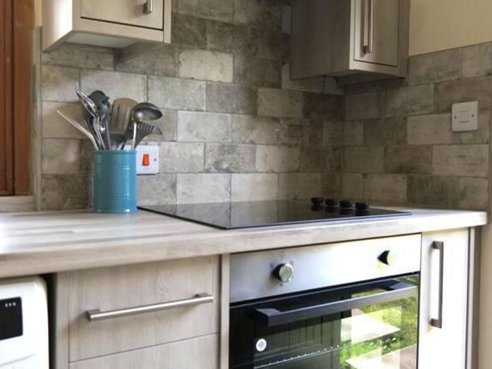 A kitchen with a stove and cooking utensils at Cottage Sleeps 2 Garden Parking Ryton