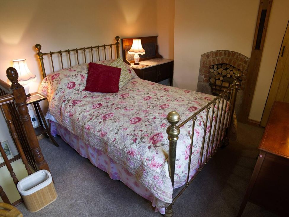 A bedroom with a brass bed and nightstand at Cottage Sleeps 2 Garden Parking in Ryton