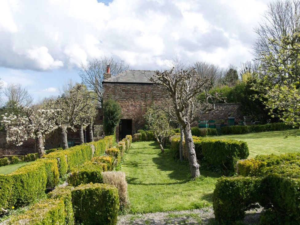 A garden with trees and a path leading to a building at Cottage Sleeps 2 Garden Parking in Ryton