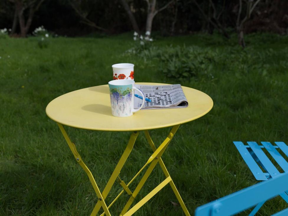A table with cups and a newspaper at Cottage Sleeps 2 Garden Parking in Ryton