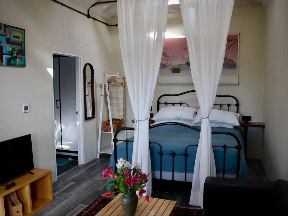 A bedroom with a bed and flowers on a table at Little Linney Sleeps 2 Garden Parking Wifi in Hartland