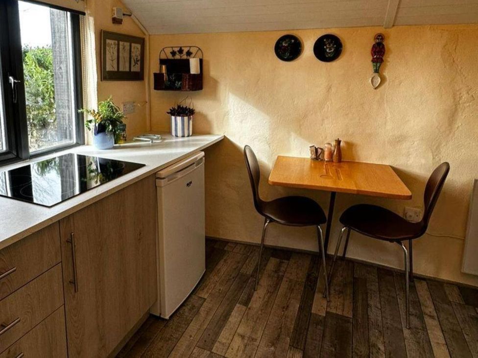A kitchen with a stove and table at Little Linney Sleeps 2 Garden Parking Wifi Hartland