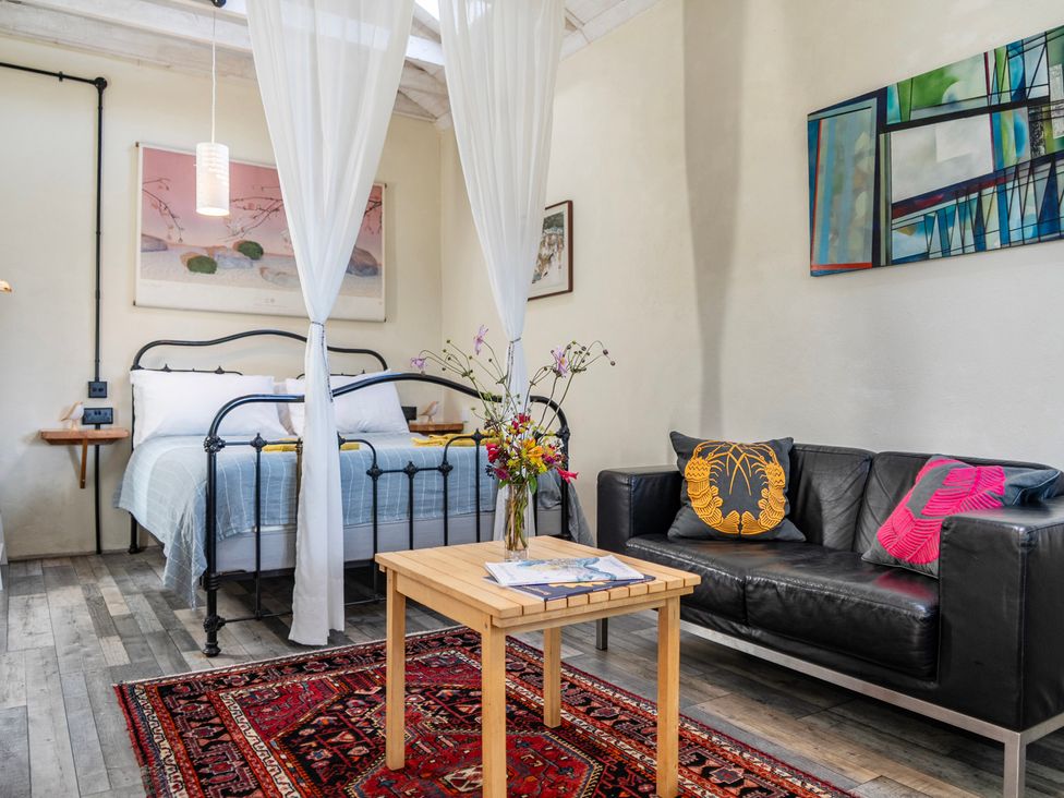 A bedroom with a bed and a sofa at Little Linney Sleeps 2 Garden Parking Wifi in Hartland