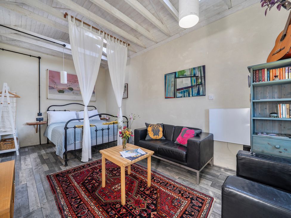 A bedroom with a bed, sofa, and table at Little Linney Sleeps 2 Garden Parking Wifi in Hartland