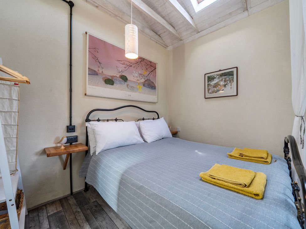 A bedroom with a bed and wall art at Little Linney Sleeps 2 Garden Parking Wifi in Hartland