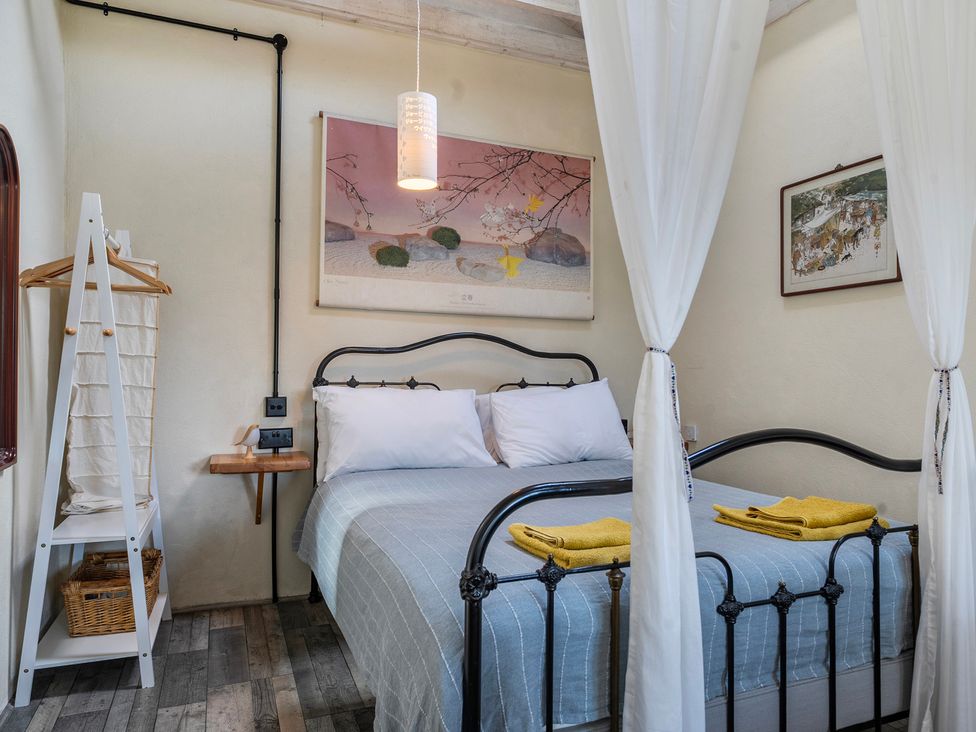 A bedroom with a bed and artwork at Little Linney Sleeps 2 Garden Parking Wifi Hartland