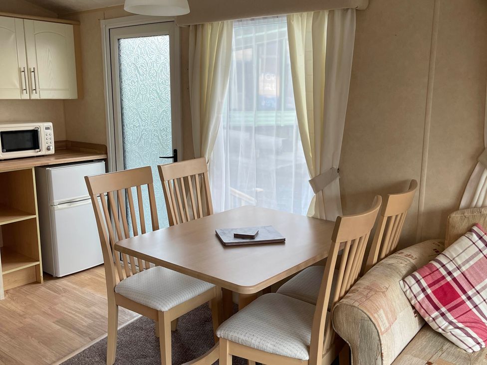 A dining area with a table and chairs at Beautiful 2 Bed Static caravan