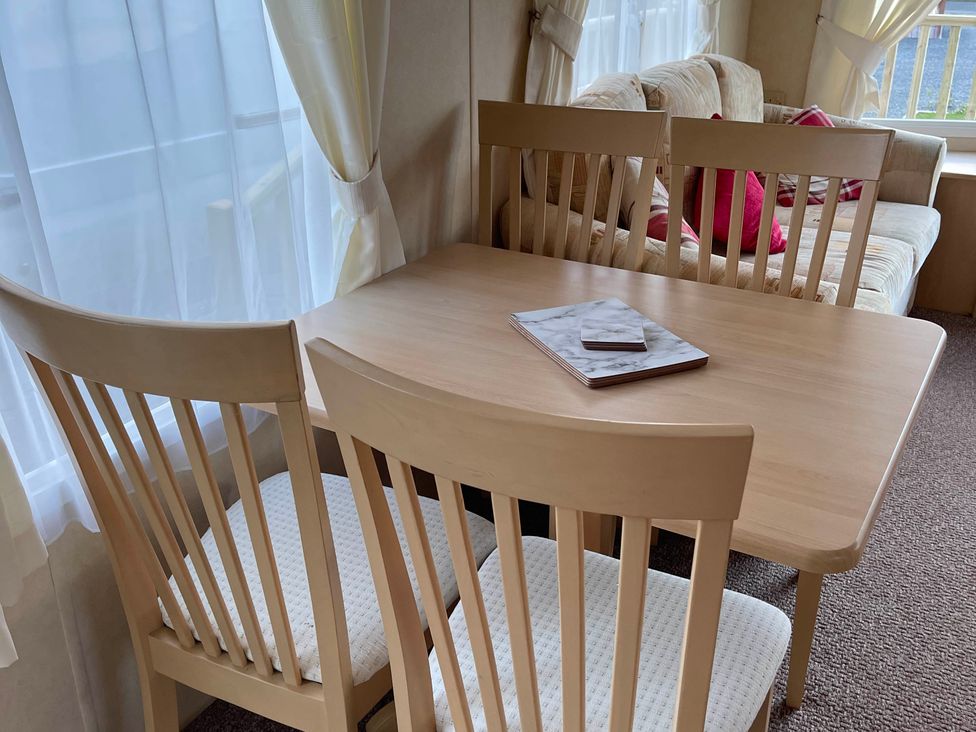 A dining area with a table and chairs at Beautiful 2 Bed Static caravan