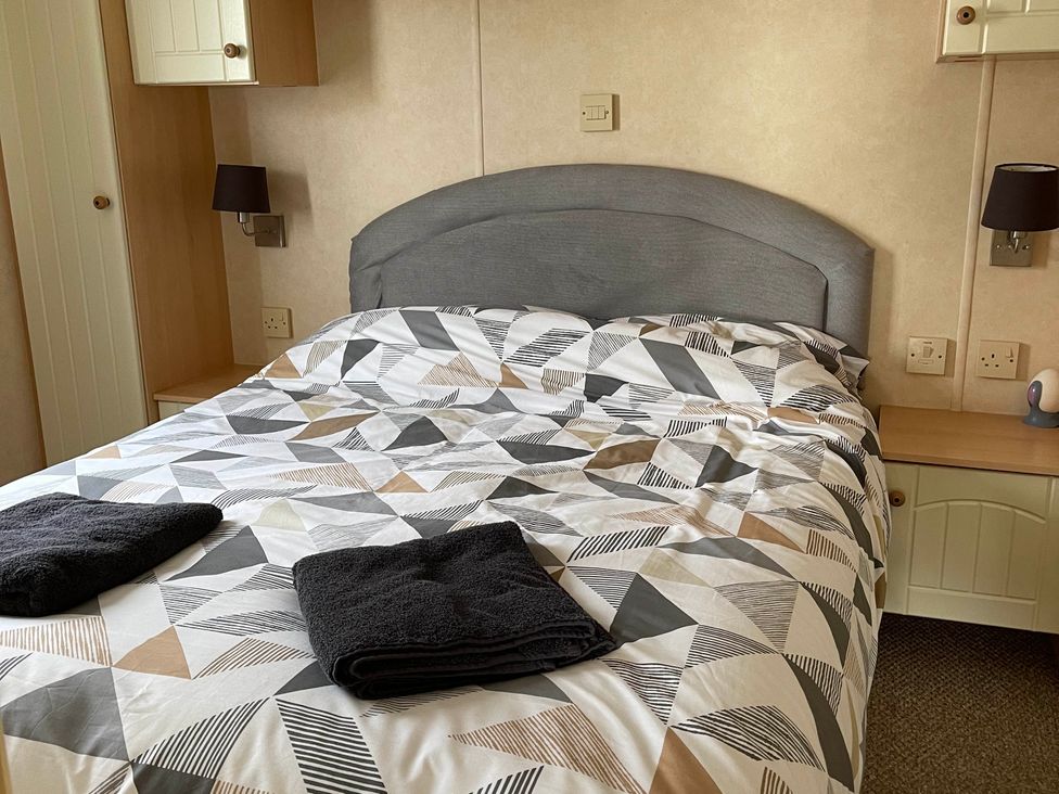 A bedroom with a bed and nightstands at Beautiful 2 Bed Static caravan