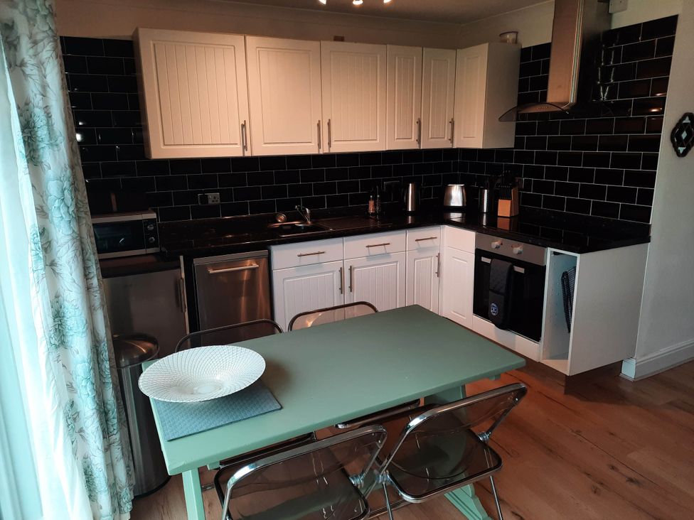 A kitchen with appliances and a table at St Margaret's 2 Bed Chalet Sleeps 4 Pets Ok