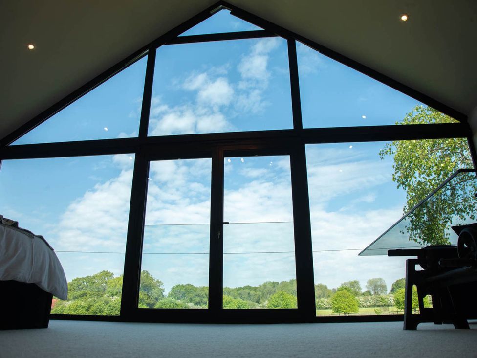 A bedroom with large windows and a view at House Sleeps 10 with Enclosed Garden Checkendon near Henley-On-Thames